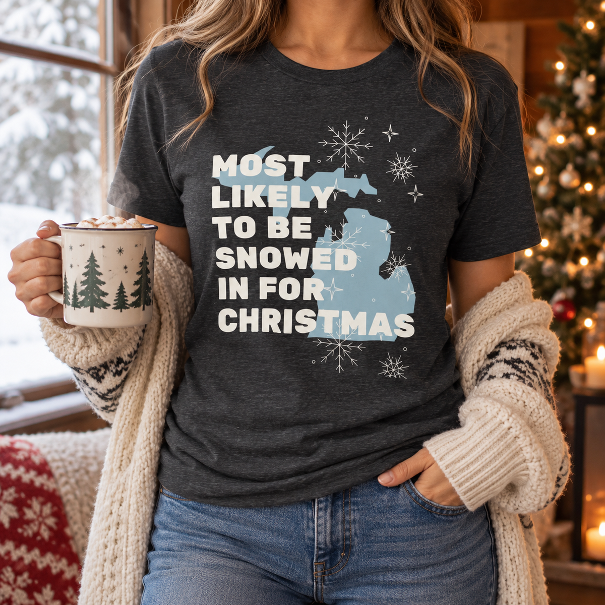Dark Grey Heather Snowed In for Christmas tee by snowy window with hot cocoa
